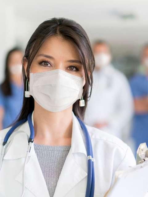 Female doctor with a group of doctors in background